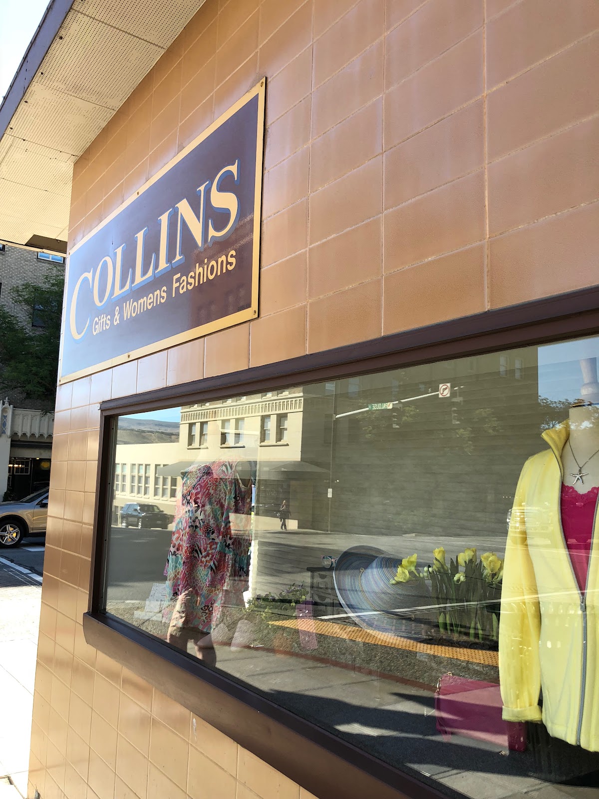The gold Collins Gifts & Womens Fashions sign above the downtown Wenatchee storefront window display
