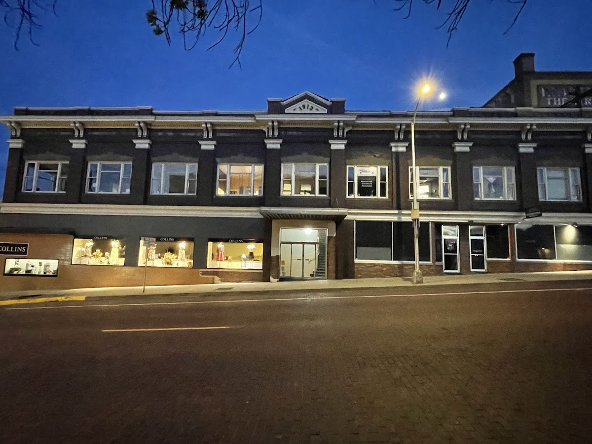 The historic 1913 building in downtown Wenatchee where Collins Fashions has its storefront, lit at dusk